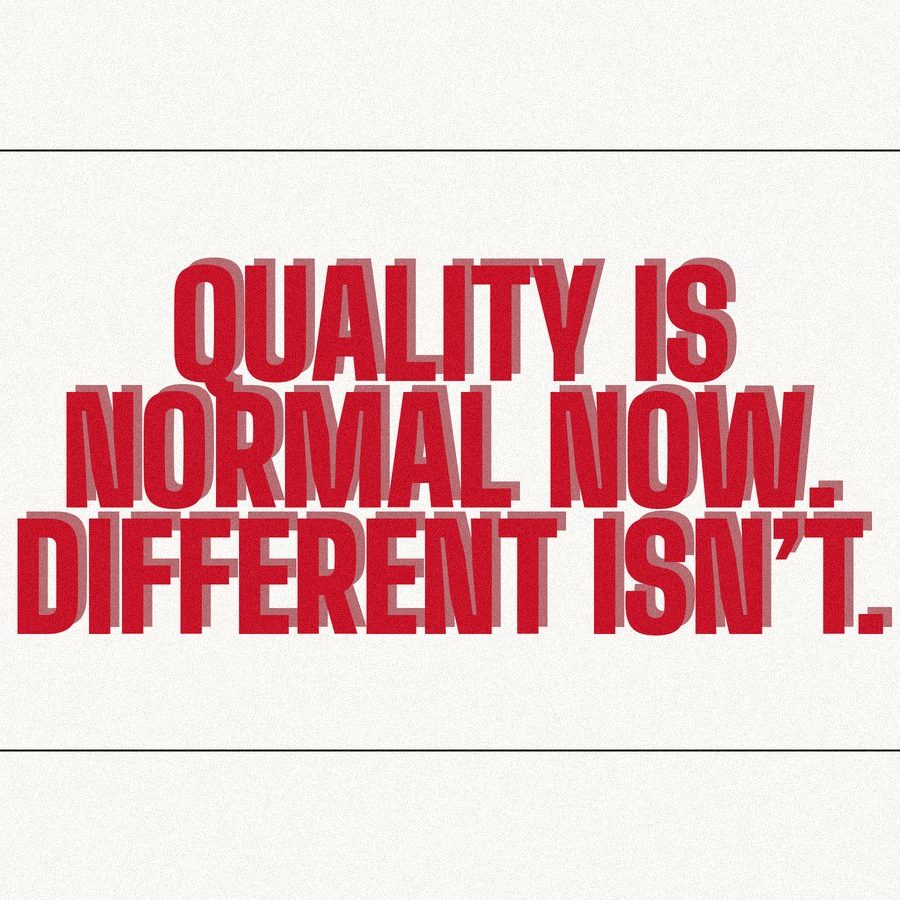 Screen-print poster reading "Quality is normal now. Different isn't." in heavy red condensed type on paper.