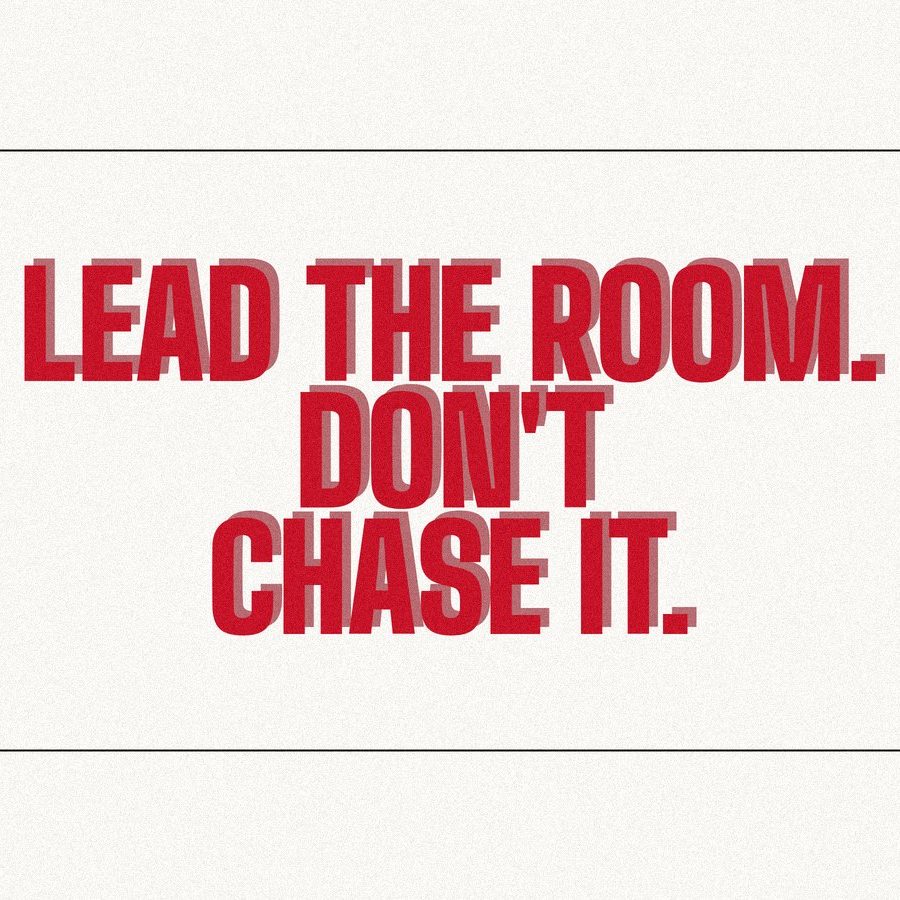 Screen-print poster reading "Lead the room. Don't chase it." in heavy red condensed type on paper.